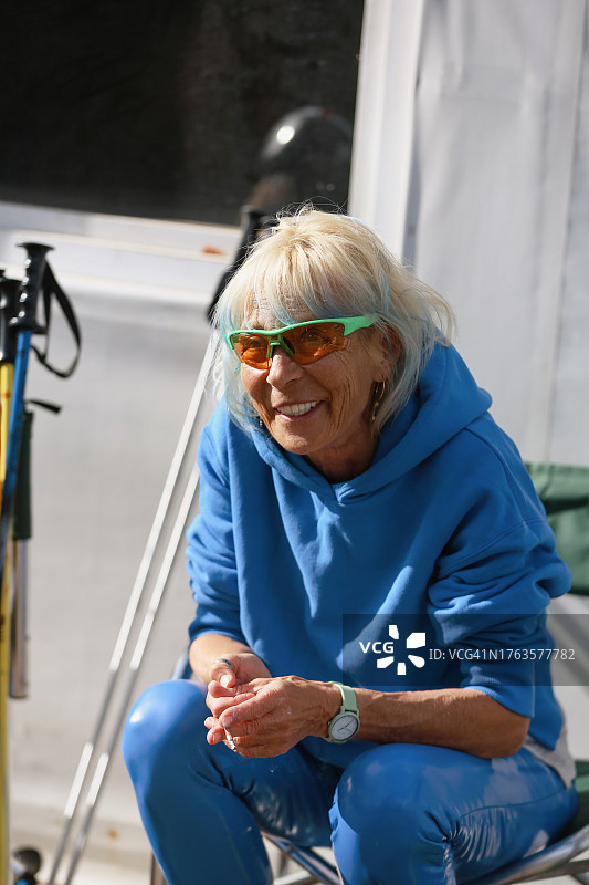 染蓝色头发的年长女教练，轮滑训练后放松图片素材