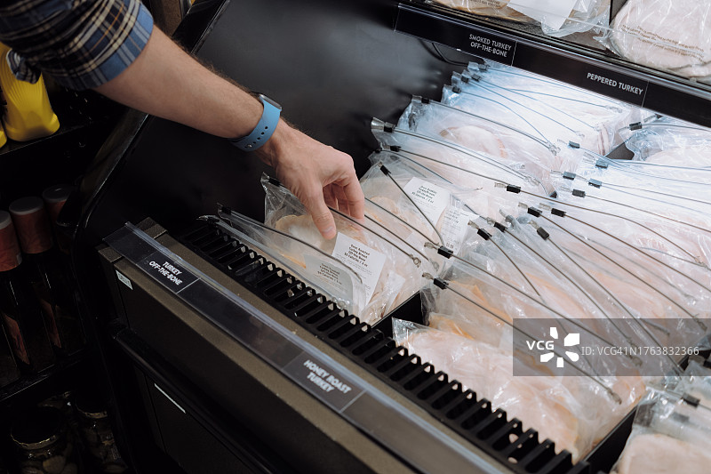 男人在超市购买熟食肉图片素材