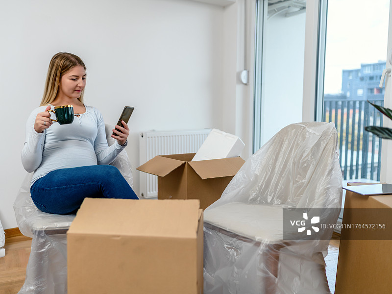年轻女人在新房里使用手机图片素材