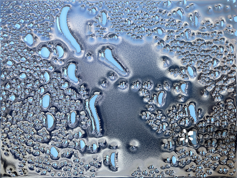 银色金属白炽液体滑过蓝色粗糙表面图片素材