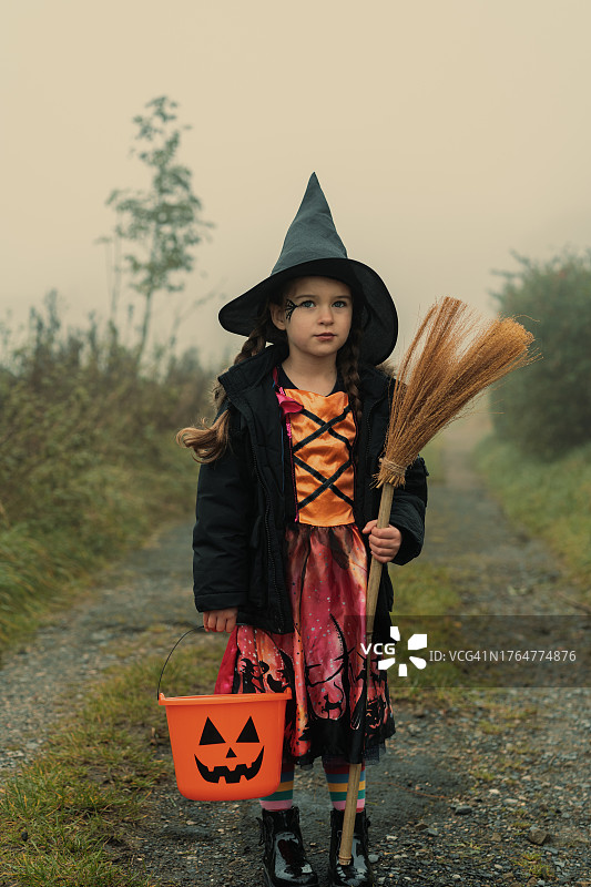 打扮成女巫准备不给糖就捣蛋的小女孩的肖像图片素材