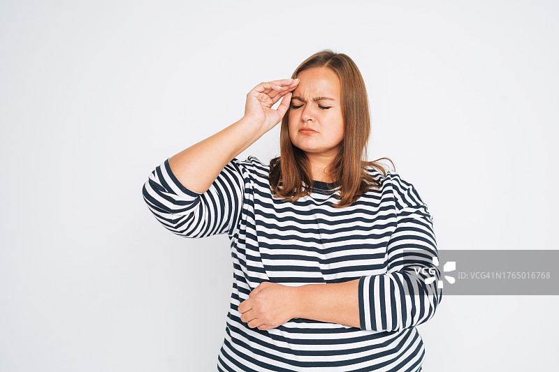 白色背景下穿条纹衫的超大码年轻女子肖像图片素材