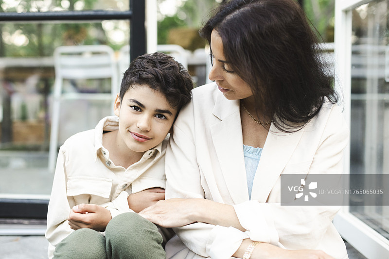 坐在后院母亲身旁的男孩肖像图片素材