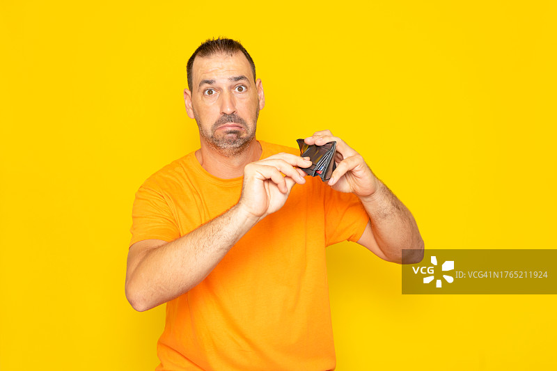 在黄色背景下拿着钱包的男人肖像图片素材