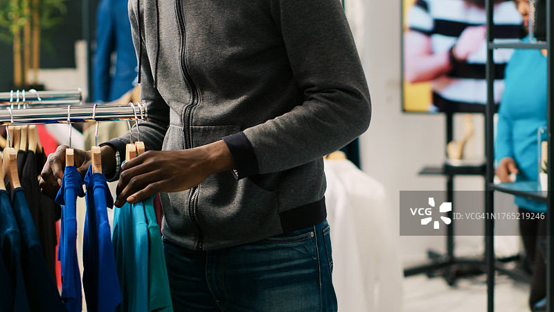 男子站在商店里挑选西装图片素材