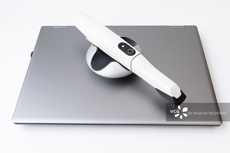 白色背景上的3D口内牙科扫描仪和笔记本电脑图片素材