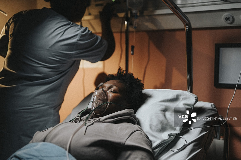 女护士在医院照顾睡在床上的危重病人图片素材