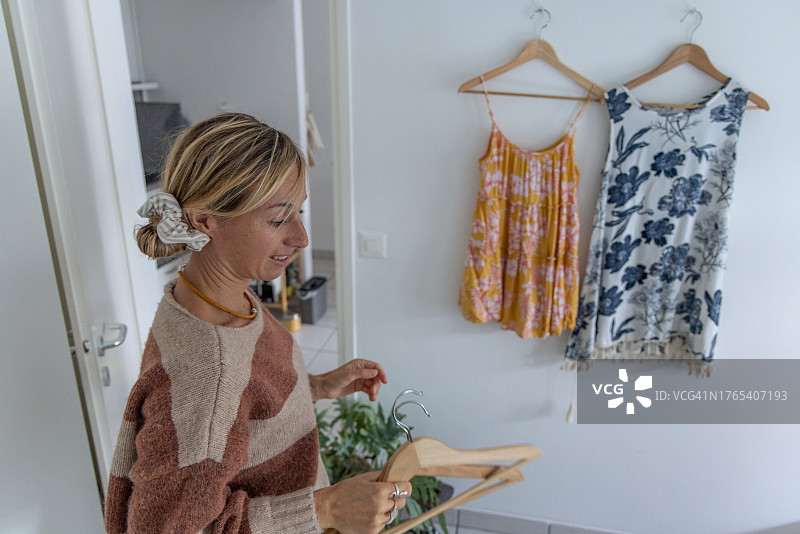 女人在网上出售二手衣服，副业概念图片素材