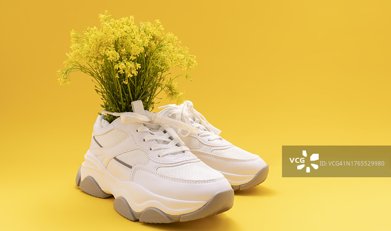 黄色花朵特写，白色鞋子，黄色背景图片素材