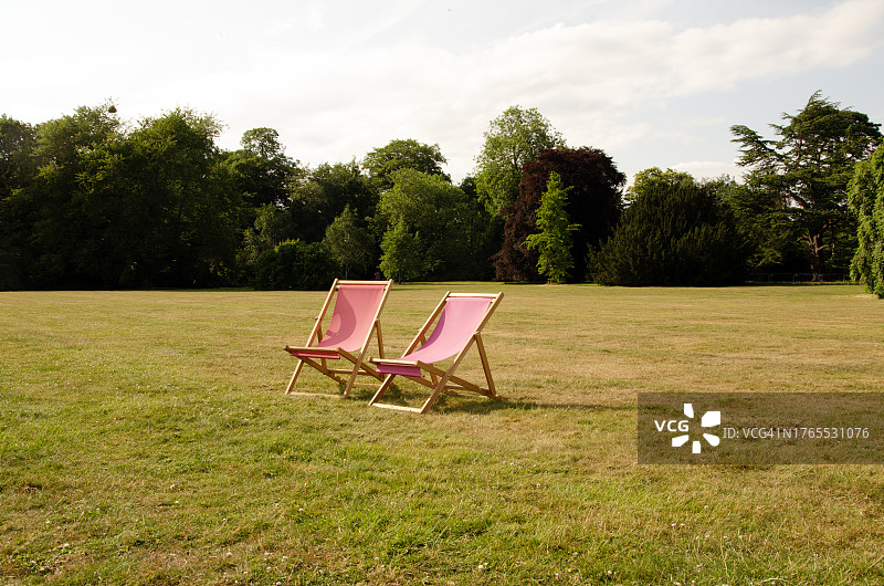 阳光下草坪上的木制甲板椅，英国图片素材