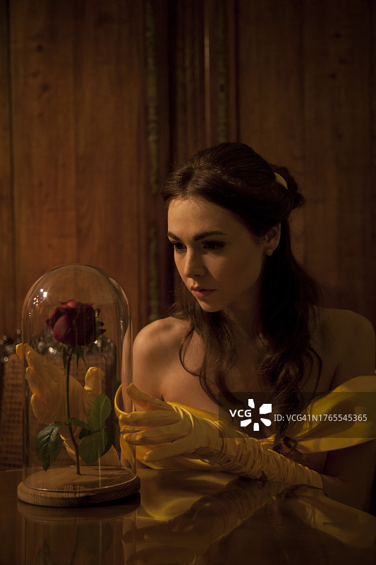 年轻女子看着一朵玫瑰图片素材