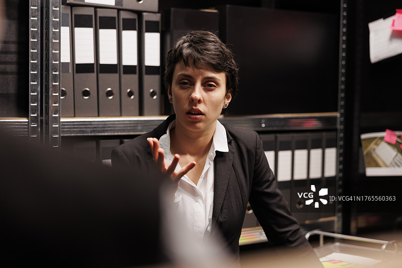 私人侦探与警官在办公室讨论失踪人员案件图片素材