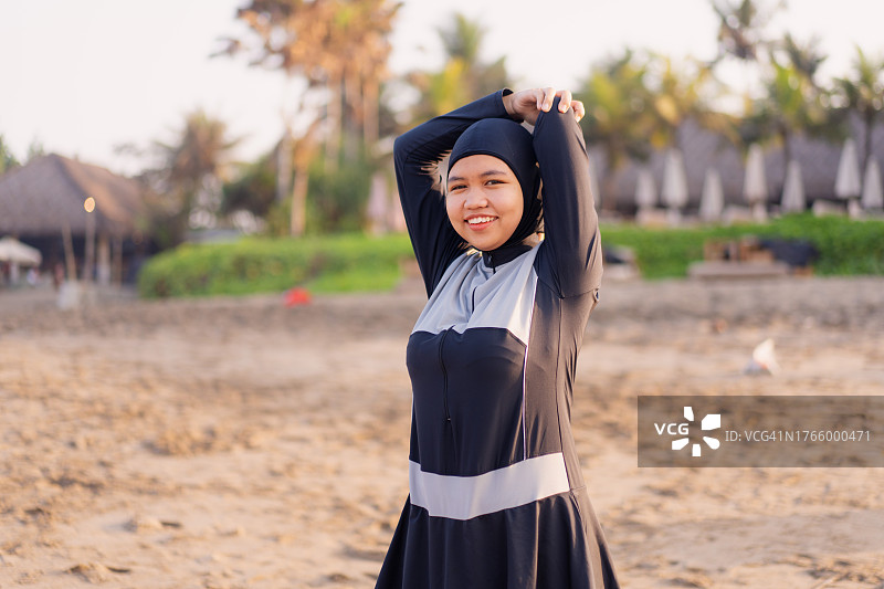 在海滩伸展热身的印尼穆斯林妇女（穿着保守泳衣）图片素材