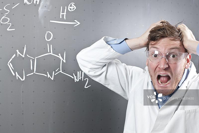 德国：表情愤怒的年轻科学家和黑板上的化学方程式图片素材