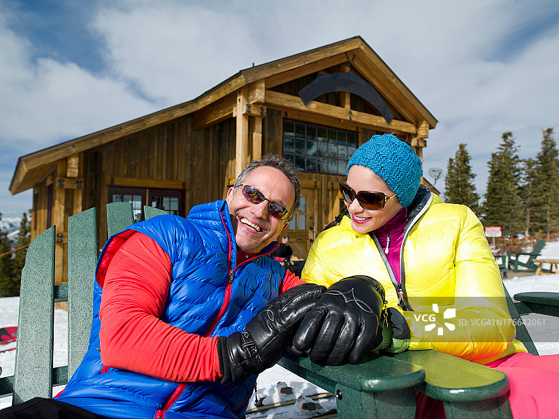 中年男人和年轻女人在滑雪胜地放松身心图片素材
