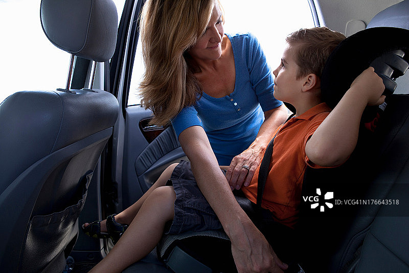 母亲在车内系儿童安全带图片素材