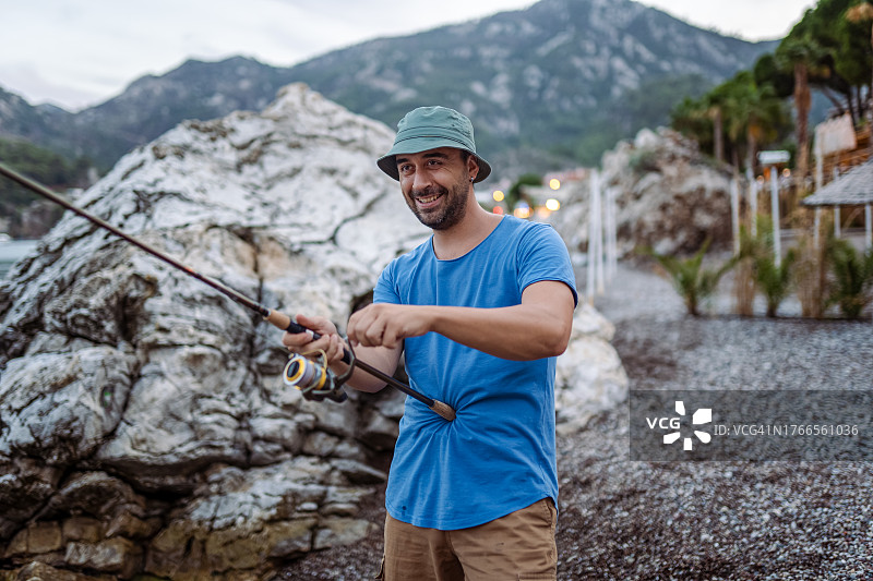 男人在海滩钓鱼放松图片素材