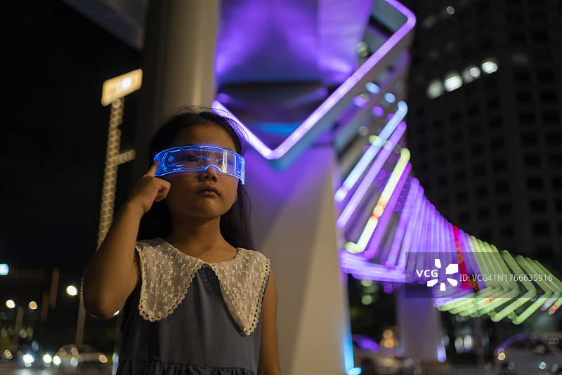 戴着发光眼镜玩游戏的亚洲小女孩图片素材