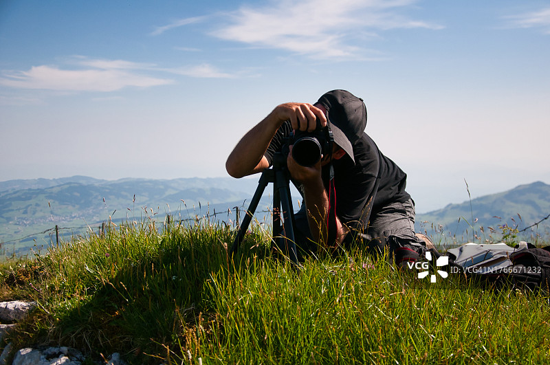 摄影师在瑞士阿尔卑斯山用三脚架拍摄照片图片素材