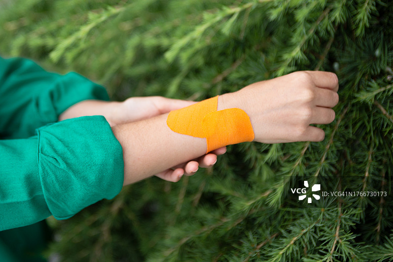 手部关节疼痛的女性特写摄影，橙色弹性绷带，留有文字空间图片素材