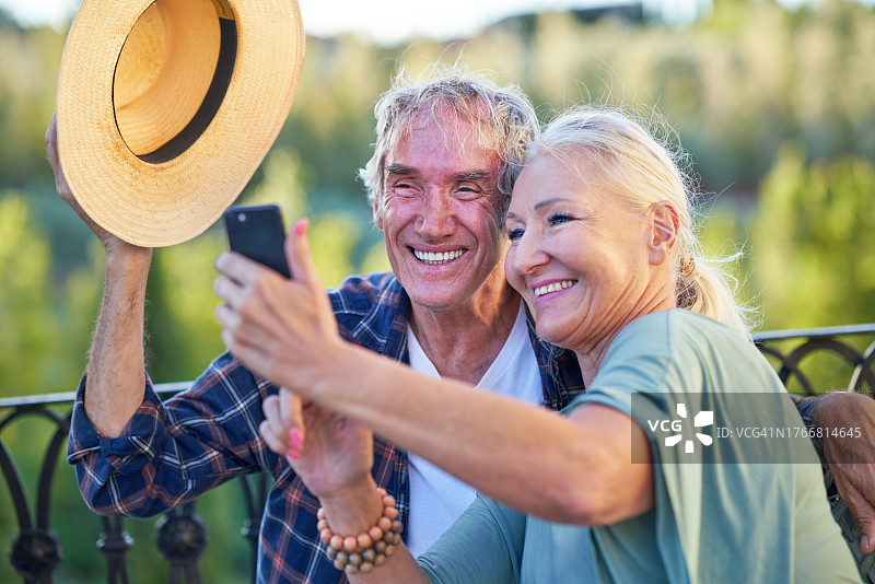 快乐的老年夫妇在阳台上自拍图片素材