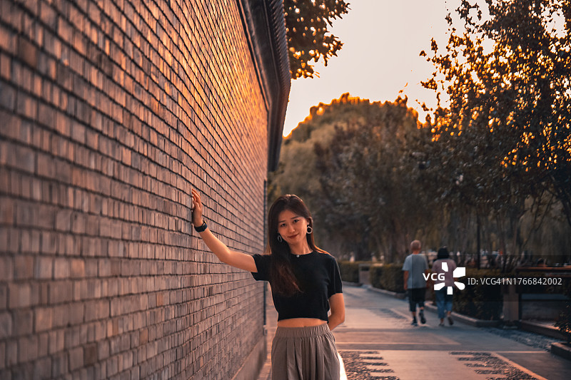 北京南锣鼓巷日落下的美丽女人肖像图片素材