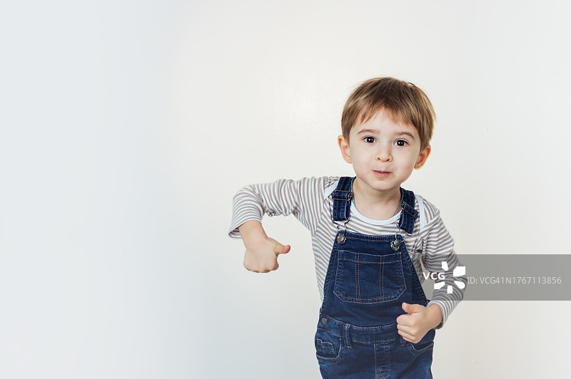 站在白色背景前的可爱男孩肖像图片素材