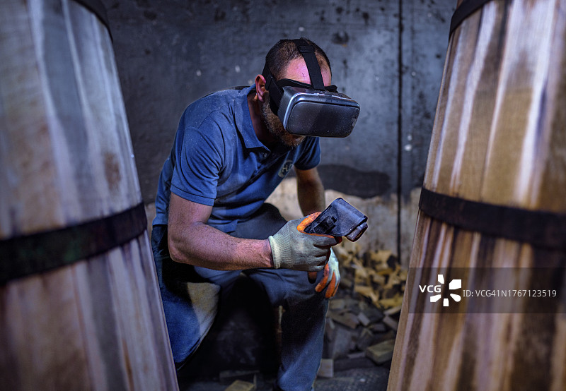 工人在桶匠工厂工作，用测温枪和VR眼镜测量湿度和温度图片素材