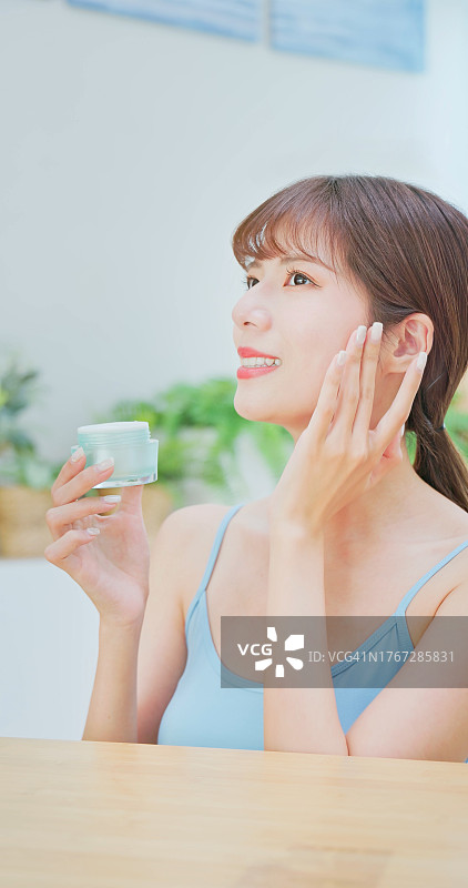 女人涂抹润肤乳和面霜图片素材