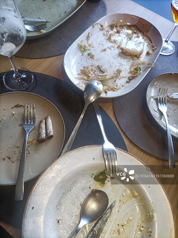 摆放美味餐后剩余食物的餐盘的桌子图片素材