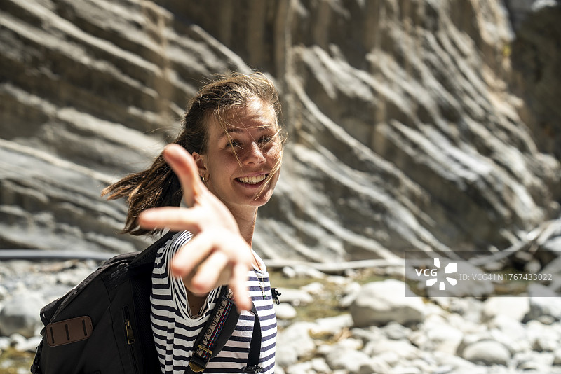 女徒步者独自在萨马利亚峡谷徒步，欣赏岩石山丘的景色图片素材
