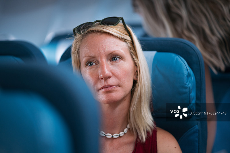 快乐的女性乘客在飞机上图片素材