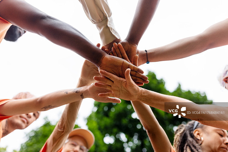 在环境清理计划期间，不同种族的志愿者叠手图片素材