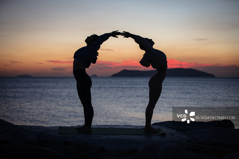 年轻女子在日落时做瑜伽图片素材