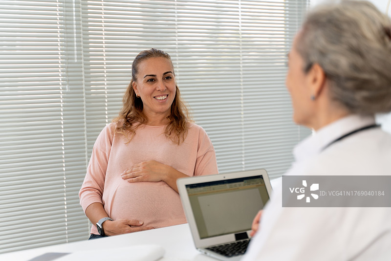 孕妇认真倾听医生讲解图片素材