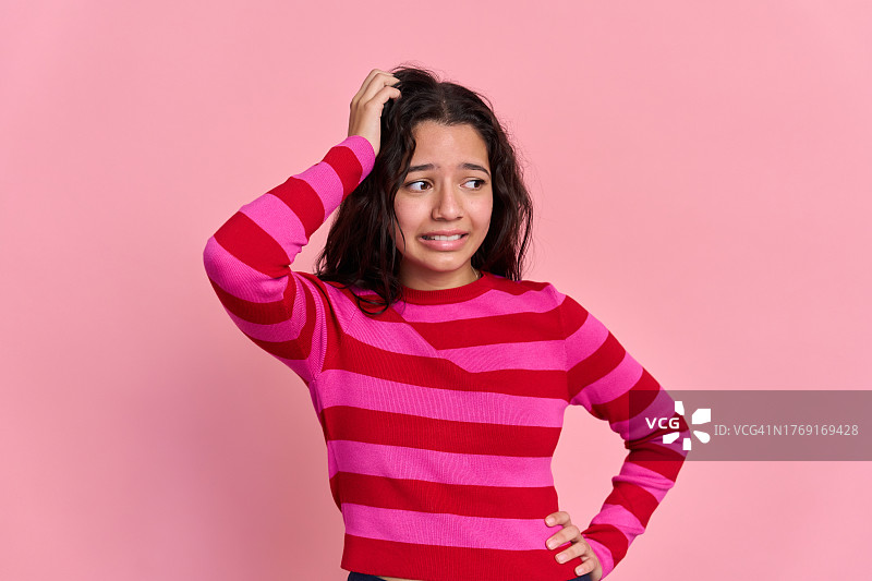 穿着粉色条纹毛衣的年轻拉丁裔女人图片素材