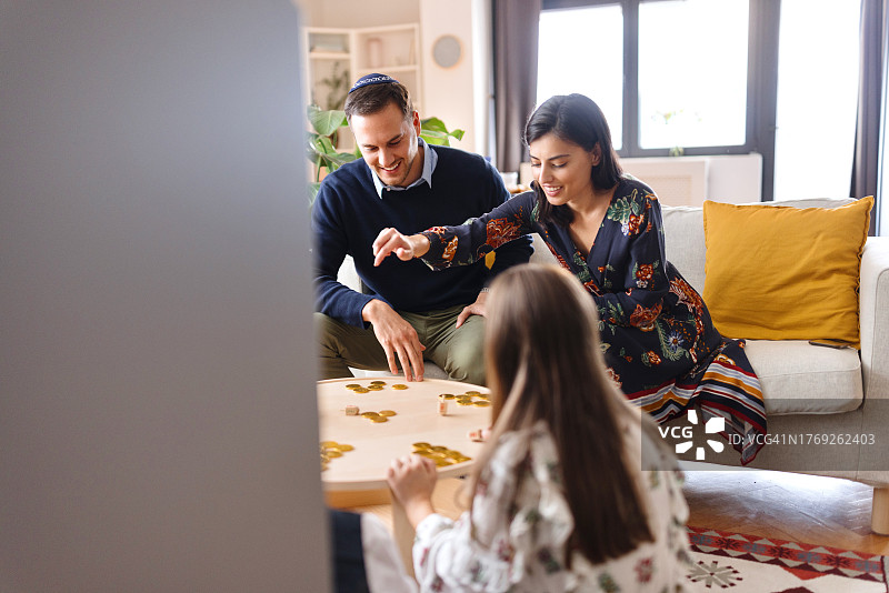 父母在光明节期间和孩子们玩游戏图片素材