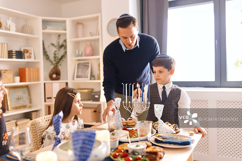 男孩在光明节点燃烛台图片素材