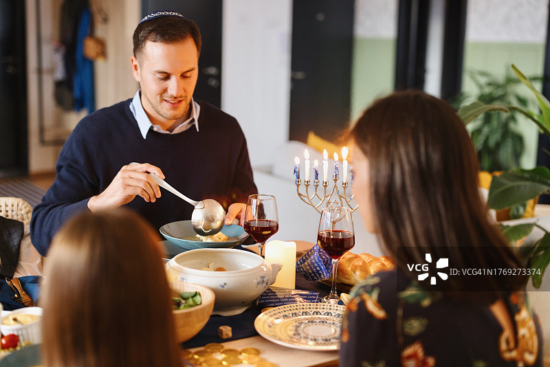 在餐桌旁吃传统Matzo球汤的男人图片素材