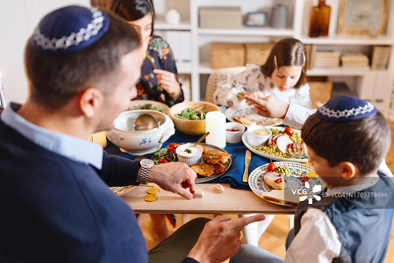 家庭在光明节期间玩陀螺图片素材