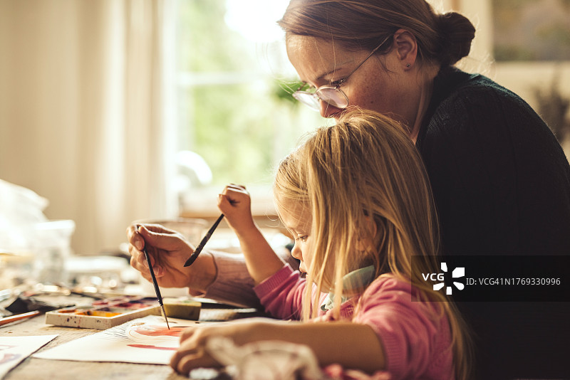母亲和女儿一起用水彩颜料绘画图片素材