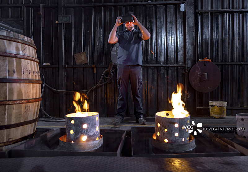 工人在桶匠工厂工作，用测温枪和VR眼镜测量湿度和温度图片素材