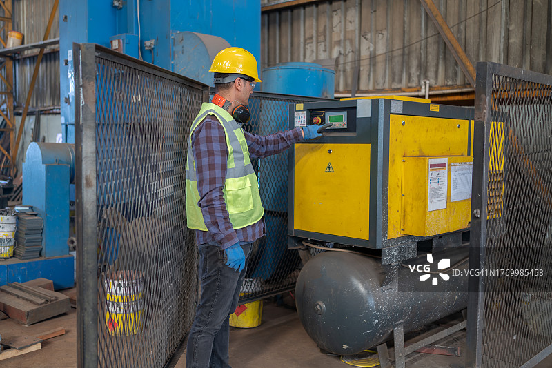 工厂工人对空气压缩机进行编程图片素材