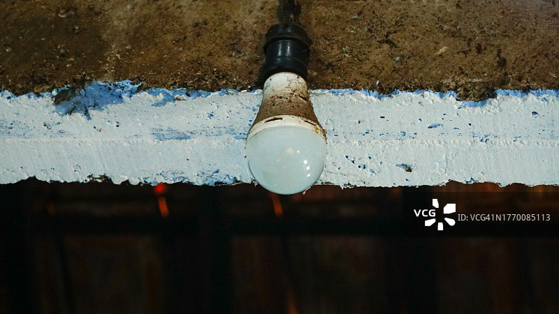 老旧的蓝色灯泡悬挂在天花板上图片素材