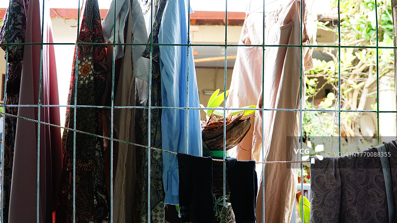 阳光明媚的日子里挂在衣架上的洗好的衣服图片素材