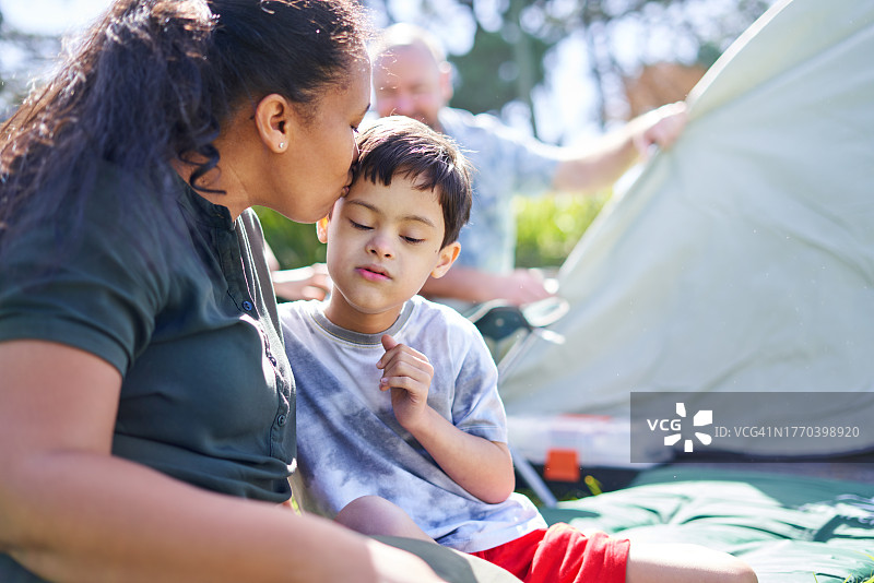 充满爱意的母亲在帐篷外亲吻患有唐氏综合征的儿子图片素材
