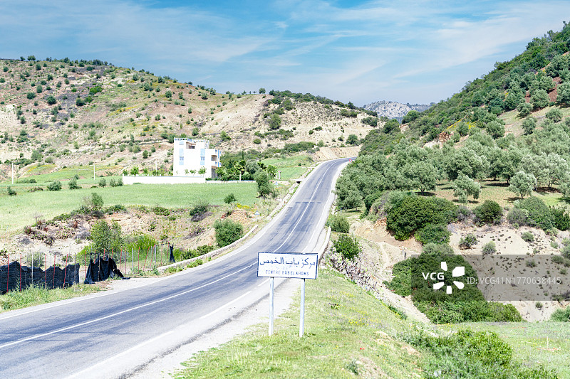 绿色山谷中穿过山脉的空旷道路图片素材