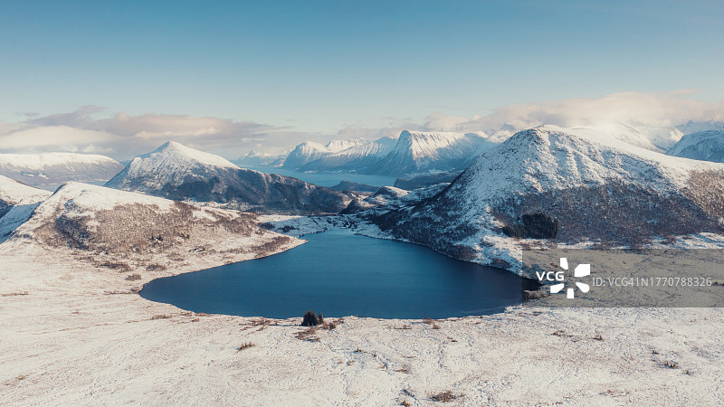 冬季挪威，风景日落时分，冰冻湖泊和峡湾的壮丽空中冬季山景图片素材