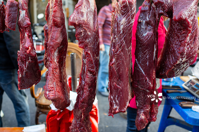街头市场出售的悬挂生牛肉图片素材