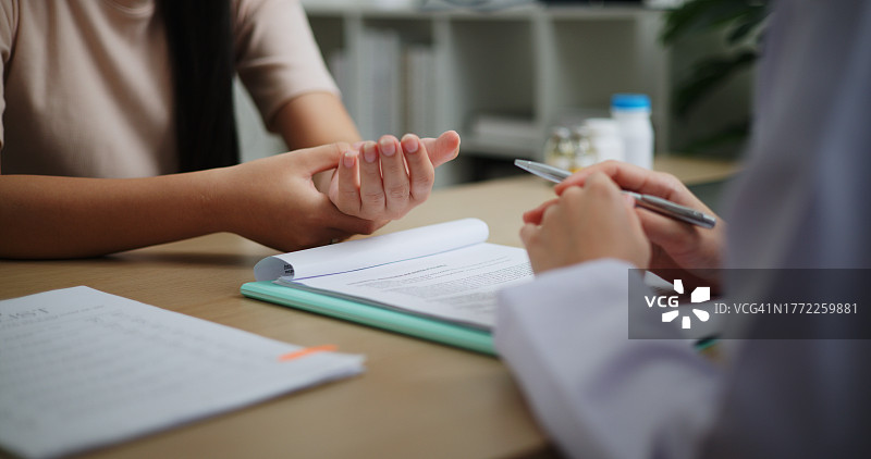 年轻女患者在医院的诊室里听医生讲解病情图片素材